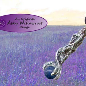 Pewter dragon-shaped pendant with black stone on cord against lavender field background