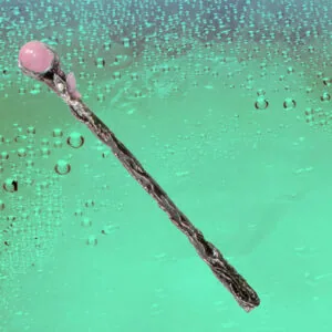 Wooden wand with pink crystal orb against turquoise background with water droplets