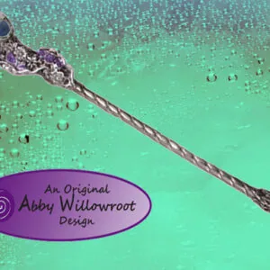 Ornate purple and silver wand with spherical head on turquoise background with water droplets