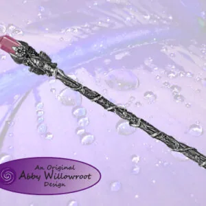 Wooden wand with red crystal point submerged in water with bubbles and purple lighting