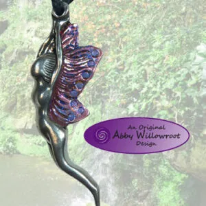 Pewter pendant on black cord featuring a stylized fairy figure with purple and blue enameled wings against a moss-covered stone background