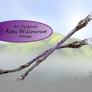 Ornate wooden wand with silver-toned metalwork and crystal points against misty mountain landscape with purple oval logo reading 'An Original Abby Willowroot Design'