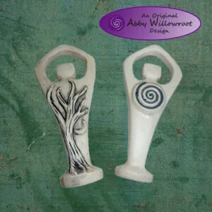 Two white ceramic pendants with loop tops, one featuring carved grass/plant motifs, the other with a spiral design, on textured green background
