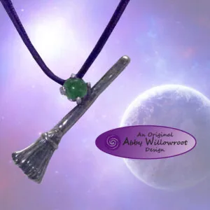 Silver broom pendant with green stone on purple cord against cosmic purple background with planet