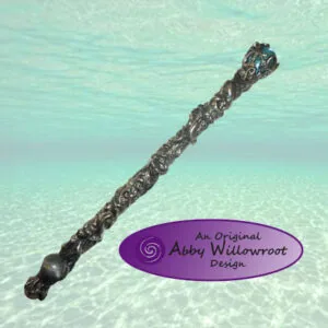 Ornate wand with twisted dark metal design underwater in turquoise water