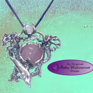 Silver ornate pendant with amethyst stone and pearl bead on dark blue cord against turquoise background