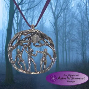 Sterling silver pendant with figures dancing around a central moon, suspended on burgundy cord against misty forest background