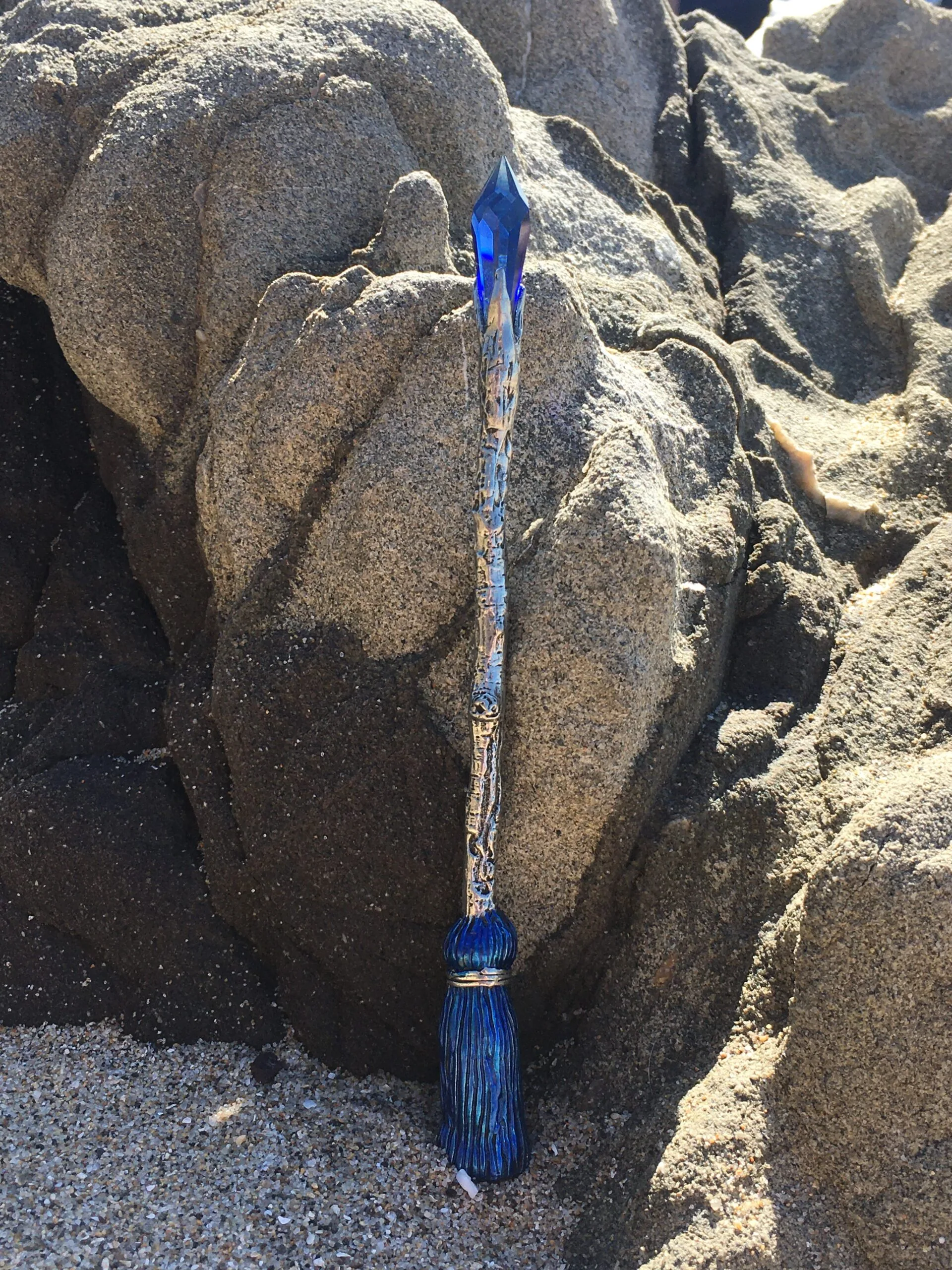 Blue paintbrush nestled between large granite boulders on sandy ground