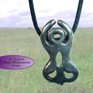 Metal pendant with curved horns and circular openings on black cord against grassland backdrop
