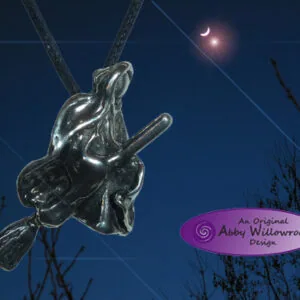 Pewter pendant shaped like a flying witch on broomstick against night sky with crescent moon and bare branches