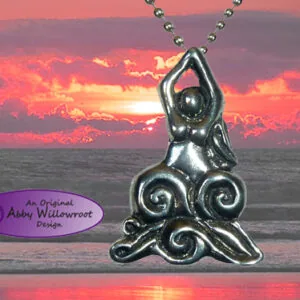 Pewter pendant with flowing spiral design hanging from ball chain against sunset ocean background