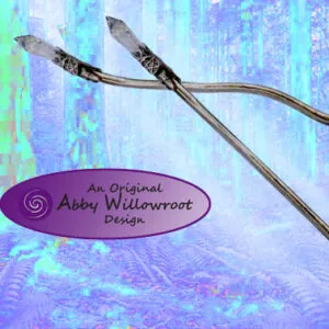 Two curved wands with dark handles crossed over a colorful purple and blue textured background with an Abby Willowroot Design label