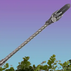 Twisted metal wand with pentacle charm against purple and blue sky above green foliage