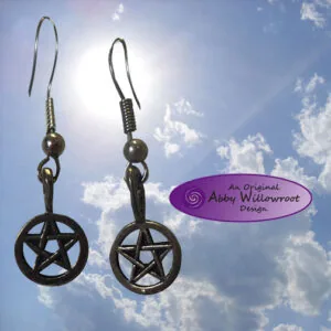 Pair of pewter pentacle star earrings hanging against blue sky with clouds