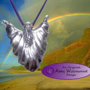 Silver winged goddess pendant with purple cords on landscape background with rainbow and mountains