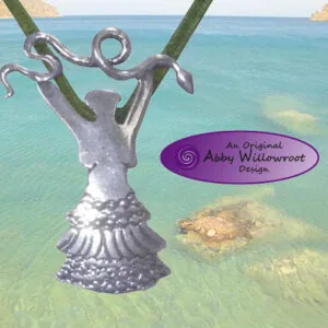 Ornate silver pendant with snake motifs hanging from rope over turquoise ocean water and rocks
