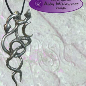 Pewter pendant featuring intertwined snakes suspended on black cord against textured white background