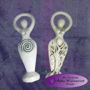 Two white ceramic goddess figurines with spiral and carved details, displayed against purple background