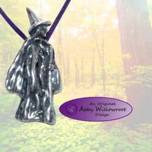 Dark metallic pendant shaped like a wizard figure with pointed hat, hanging from purple cords against a misty forest background