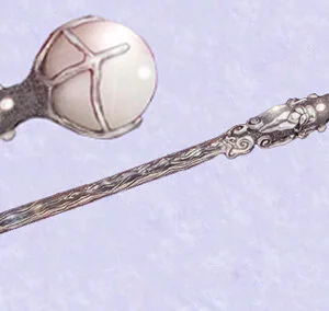 Two decorative wands with ornate metal handles and spherical white stone tops featuring carved crescent moon designs