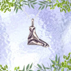 Silver pendant shaped like a figure in motion against purple textured background with green foliage corners