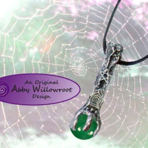 Pendant necklace with silver-toned metal charm and green stone on black cord, displayed against a spider web background with purple watermark.
